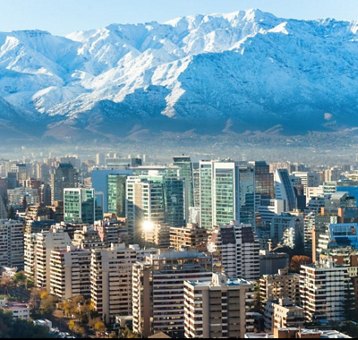 Cityscape of Santiago, Chile with modern buildings in the foreground and the snow-capped Andes mountains in the background.